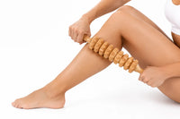 Person som masserar benet med en manuell massagerulle